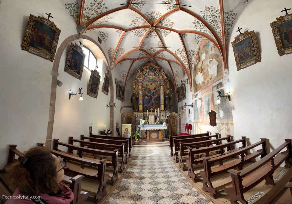 Image: Angela Corrias inside a church in San Romedio Sanctuary in Trentino Alto Adige, northern Italy. Photo by Fearlessly Italy